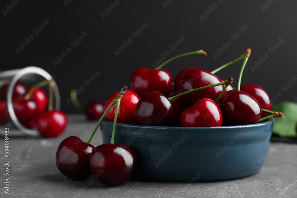 Fresh ripe cherries on grey table, closeup Fresh ripe cherries on grey table, closeup