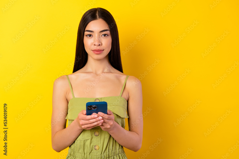 Photo of adorable pretty girl dressed green clothes chatting modern gadget empty space isolated yellow color background Photo of adorable pretty girl dressed green clothes chatting modern gadget empty space isolated yellow color background