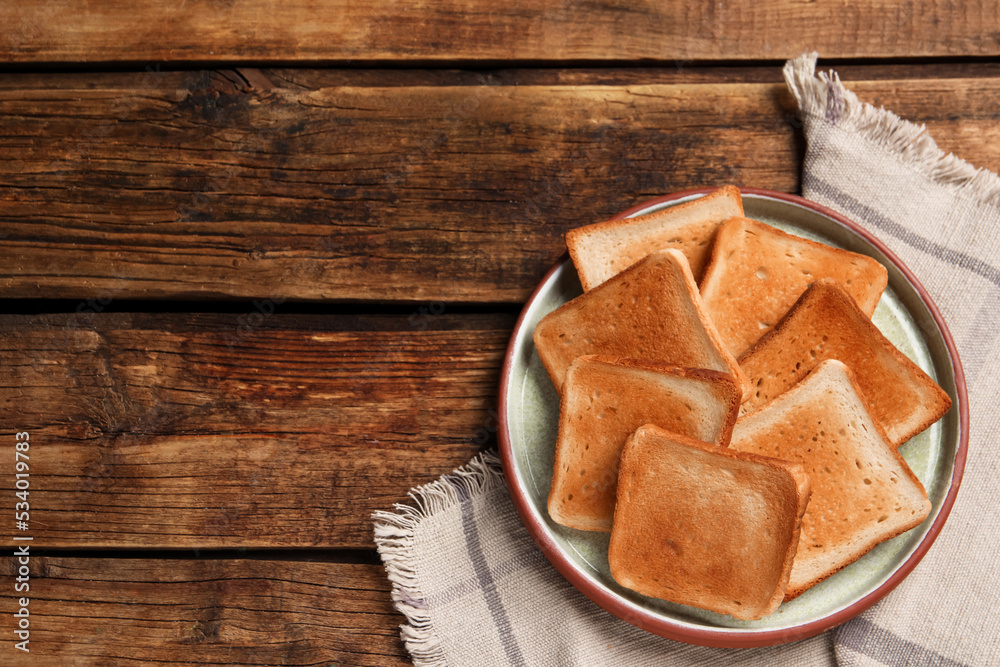 Slices of tasty toasted bread on wooden table, top view. Space for text Slices of tasty toasted bread on wooden table, top view. Space for text
