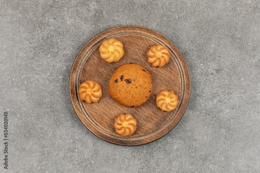 Single chocolate cookie and biscuits on wooden board Single chocolate cookie and biscuits on wooden board