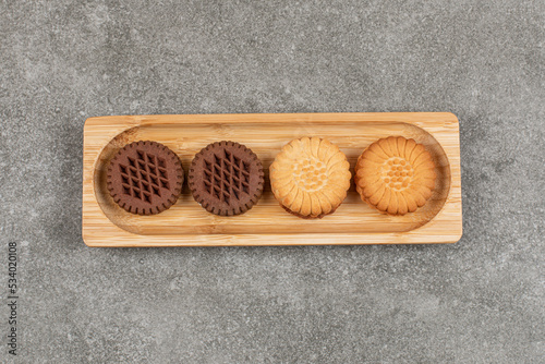 Two kinds of sandwich cookies on wooden plate photo