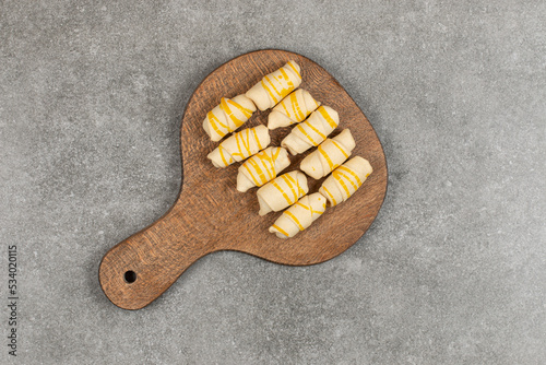 Tasty biscuits with glaze on wooden board