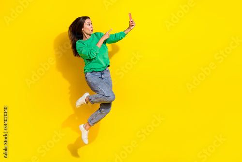 Full length portrait of impressed person jump point finger telephone isolated on yellow color background