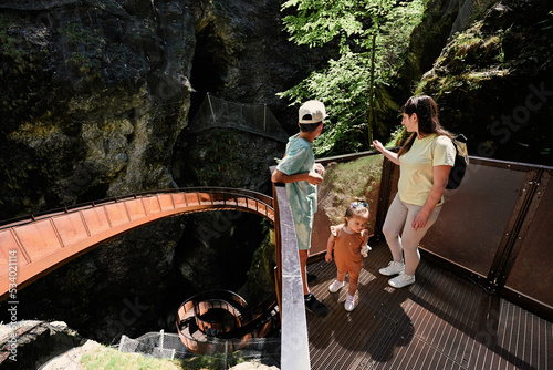 Mother with children stand in metal stairs in Liechtensteinklamm or Liechtenstein Gorge, Austria. photo