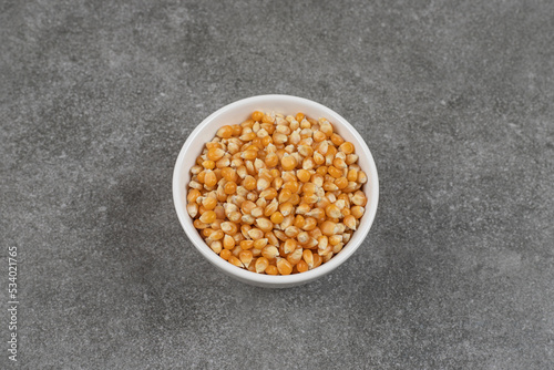 Pile of raw corn kernels in white bowl