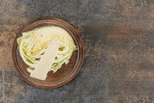 Half cabbage on the board, on the marble background