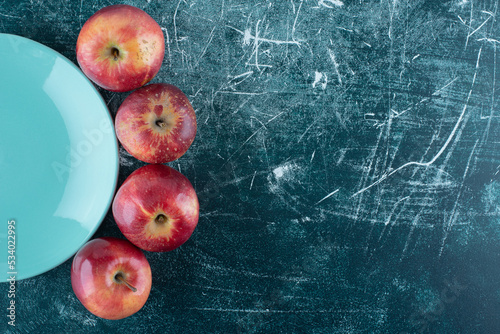 Ripe red apples on blue plate