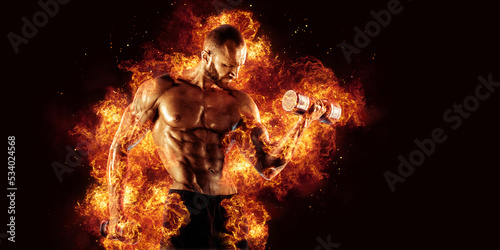 The shirtless abdominal male holds dumbbell. Studio shot in contrasty light