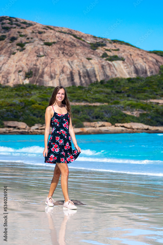 a long-haired girl in a black dress with roses walks along a paradise beach with white sand and turquoise water and orange rocks, cape le grand national park near esperance, western australia a long-haired girl in a black dress with roses walks along a paradise beach with white sand and turquoise water and orange rocks, cape le grand national park near esperance, western australia