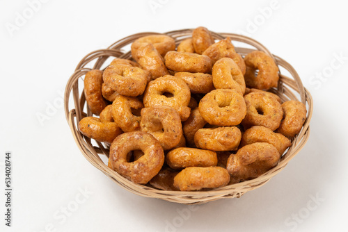 Traditional italian snacks taralli or tarallini in a wicker plate isolated on white background photo
