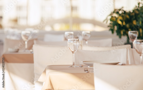 Empty wine glass standing on the table tablecloth. Luxury white colors restaurant indoor shot. © Soloviova Liudmyla