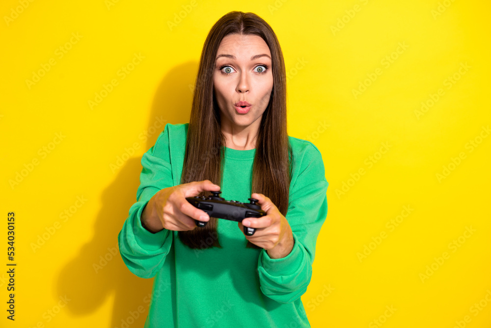 Photo of impressed person arms hold controller pouted lips play games isolated on yellow color background Photo of impressed person arms hold controller pouted lips play games isolated on yellow color background
