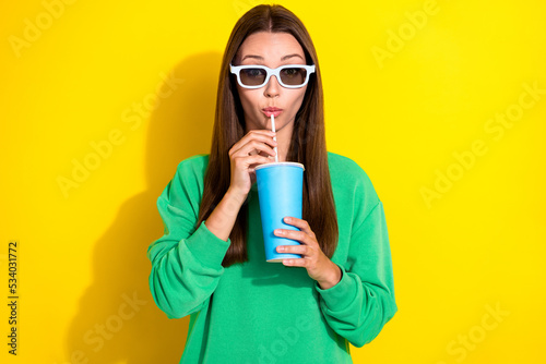 Portrait of nice young lady hands hold sipping drink cup straw isolated on yellow color background photo
