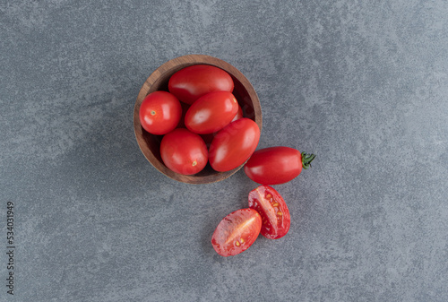 A wooden bowl of red cherry tomatoes