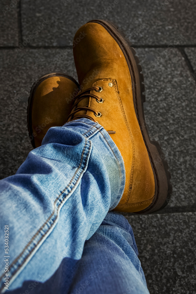 photo made of a man, in detail there are his shoes and crossed legs, he wears jeans photo made of a man, in detail there are his shoes and crossed legs, he wears jeans
