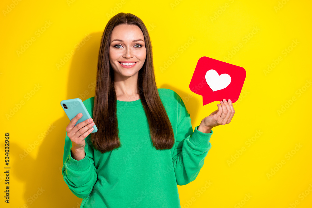 Portrait of cheerful pretty lady toothy smile hands hold paper like card telephone isolated on yellow color background