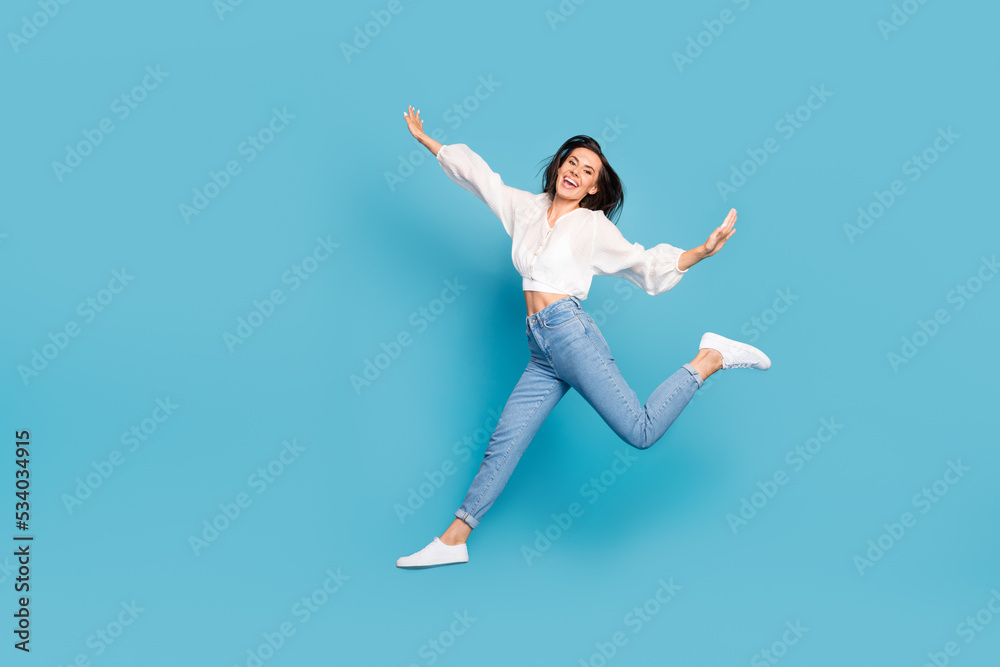 Full length photo of cheerful lovely person toothy smile jumping isolated on blue color background