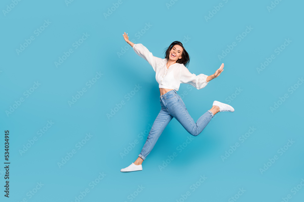 Full length photo of cheerful lovely person toothy smile jumping isolated on blue color background Full length photo of cheerful lovely person toothy smile jumping isolated on blue color background