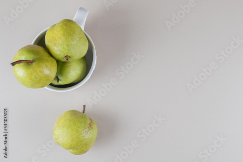 Pears in a large mug on marble background