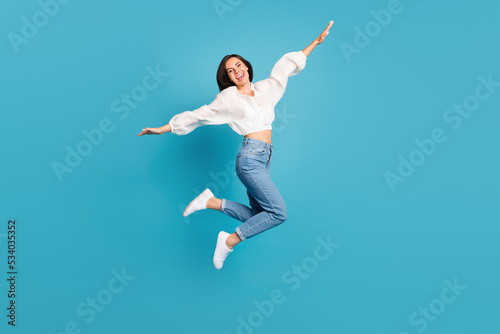Full body photo of overjoyed pretty lady jumping flying good mood isolated on blue color background