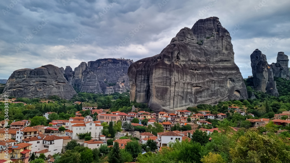 Panoramic view of the peaceful tourist village Kastraki on a mystical cloudy day in Kalambaka, Meteora, Thessaly district, Greece, Europe. Surrounded by unique view of the giant cliffs and rocks.