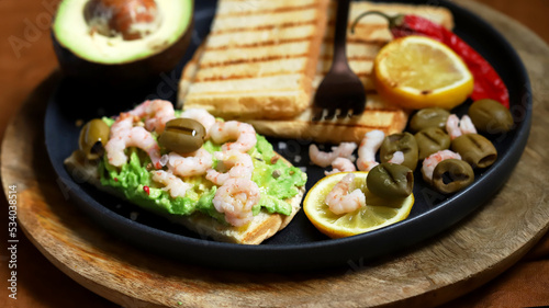 Toast with avocado paste and grilled shrimp.