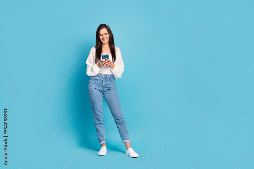 Full size portrait of charming positive girl hold use telephone empty space isolated on blue color background