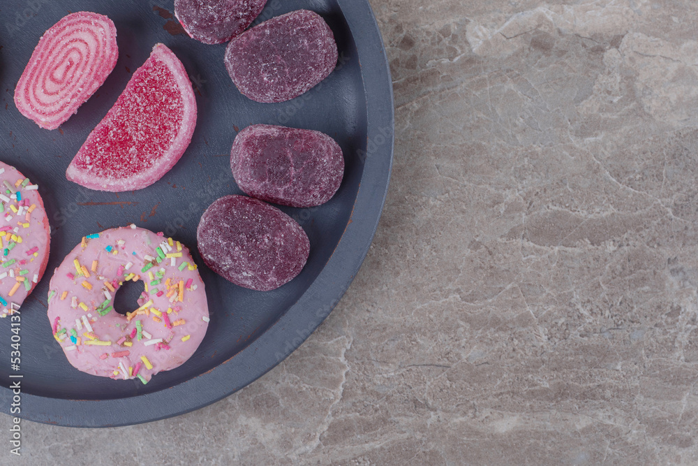 Naklejka premium Donuts and marmelades in a small serving tray on marble background