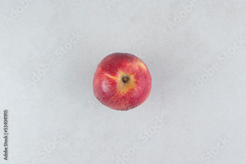Single red apple on stone background