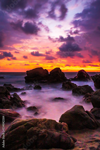 sunset on beautiful beach with big rocks, long exposure for the waves, puerto escondido oaxaca 