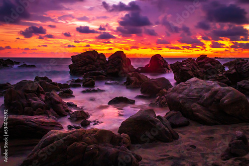 beach with a lot of rocks at sunset, with cloudy sky in puerto escondido oaxaca 