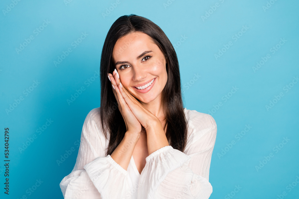 Photo of optimistic brunette lady hold arms wear white shirt isolated on blue color background Photo of optimistic brunette lady hold arms wear white shirt isolated on blue color background