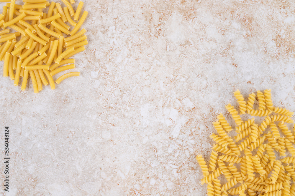 Obraz premium Two types of raw pasta on a marble background