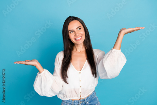 Photo of impressed brunette lady hold arms look promo wear white shirt isolated on blue color background