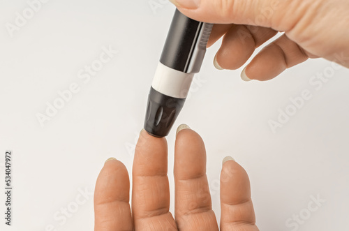 Close-up Of elderly woman Hand Holding Sugar Level Checking Machine