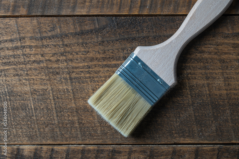 Paint brush on a wooden background, top view, closeup Paint brush on a wooden background, top view, closeup
