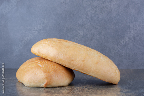 Two oval buns displayed on marble background