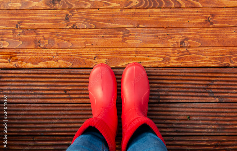 woman in red boots on the porch of the house before a walk in autumn