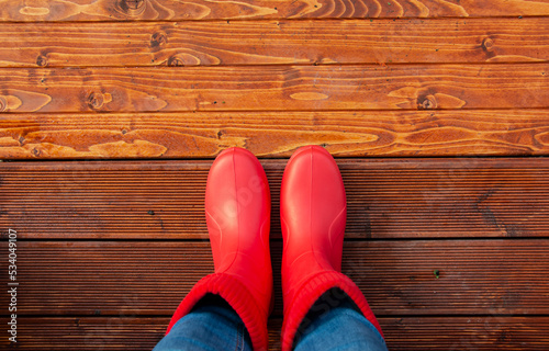 woman in red boots on the porch of the house before a walk in autumn