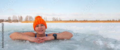 Winter swimming. 50-year-old woman in a hole in a frozen lake. Recovery and extreme swimmers in ice water. hardening youth .Place for text