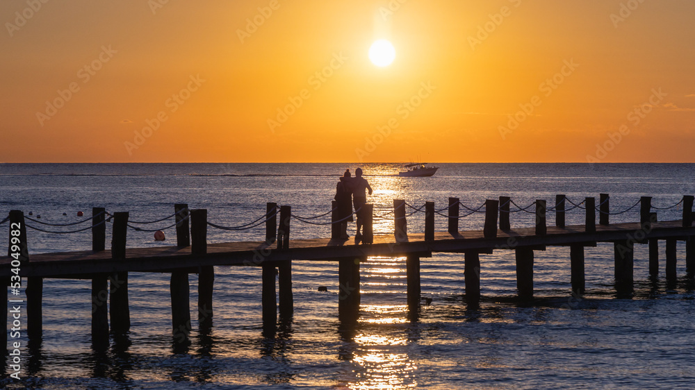Sunset in Cozumel with a pier and the ocean