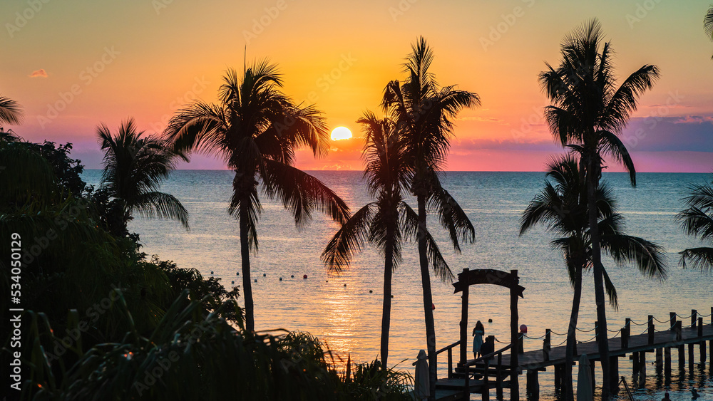 A vibrant sunset over a beach in Cozumel Mexico
