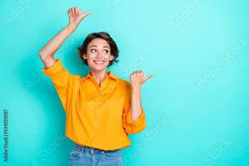 Photo of impressed ecstatic lovely girl bob hairdo dressed yellow blouse directing empty space sale isolated on turquoise color background