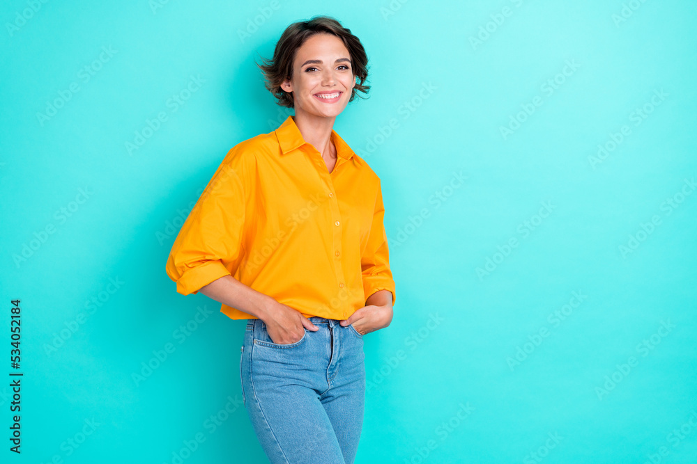Photo of confident adorable woman bob hairstyle wear yellow blouse denim jeans arms in pockets isolated on turquoise color background Photo of confident adorable woman bob hairstyle wear yellow blouse denim jeans arms in pockets isolated on turquoise color background