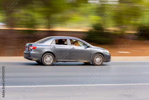 Panning shot of a car driving on a highway. Blurred photo © ali