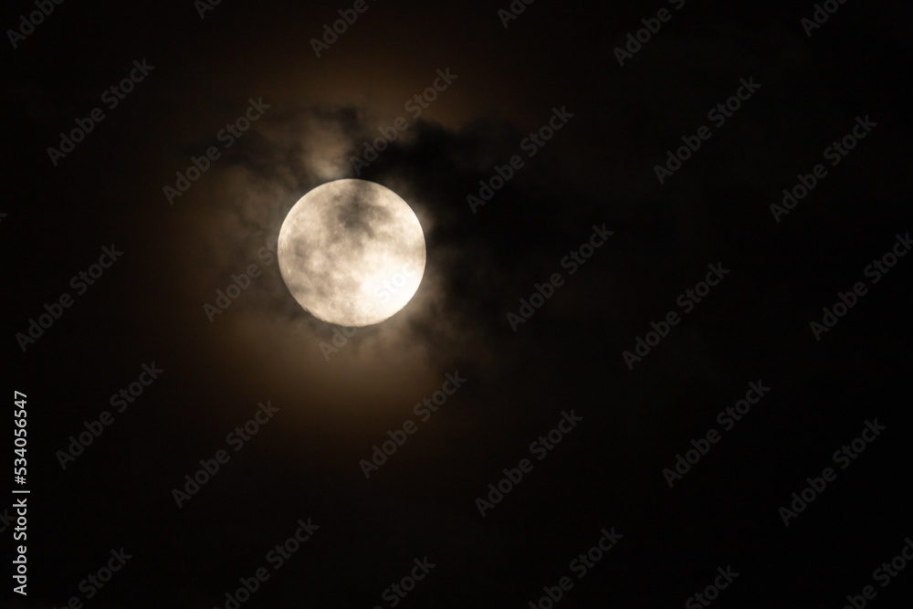 full moon, obscured by clouds