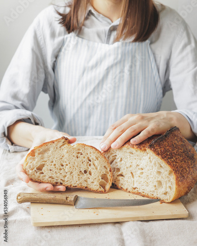 woman cooks homemade yeast-free sourdough bread. Healthy food. a woman baker in a light apron is baking bread in the kitchen, and in a pastry shop she is holding pastries in her hands. confectionery