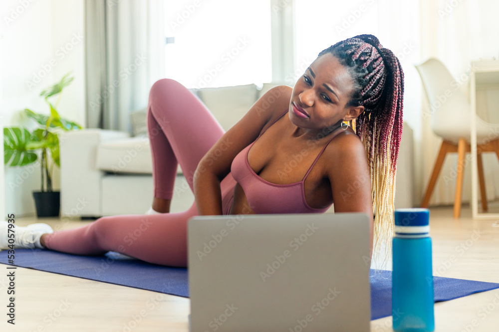 Fitness beginner. Exhausted black lady exercising with laptop, tired after  online workout, lying on yoga mat Stock Photo | Adobe Stock