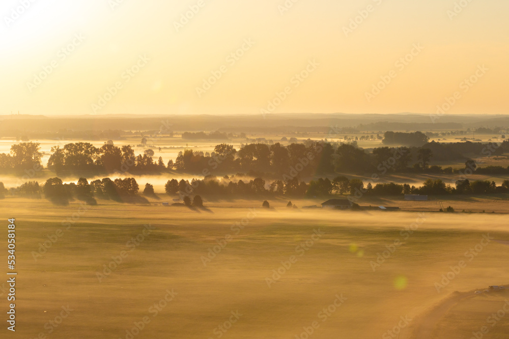 Obraz premium Aerial shot of misty sunrise full of sun 