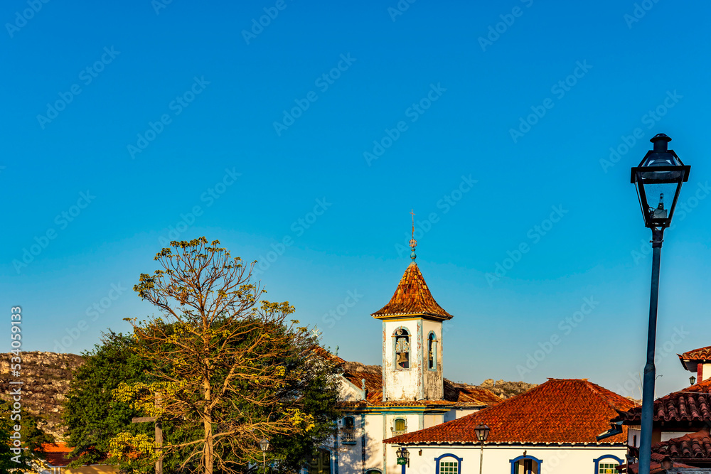 Baroque church tower with bell rising through the trees and roofs of the historic town of Diamantina in Minas Gerais, Brazil